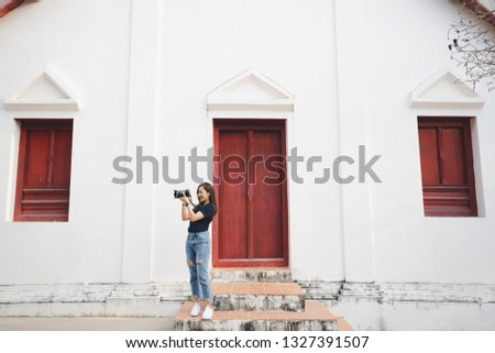 tourist woman a photographer stand in temple in traveler in vacation in Thailand nan province