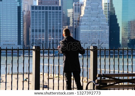 Man looking on Manhattan from Brooklyn embankment
