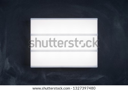 Lightbox luminous display without letters on the dark chalk board. Place for text or your design mock up.