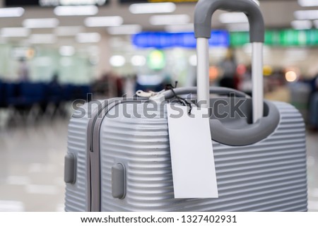 Luggage holder tag blank label on suitcase / baggage put letter "Travel insurance" word for display your products near combination locks for traveling luggages in airport terminal, copy space for text