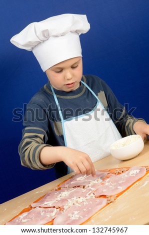 photograph of a child preparing a pizza