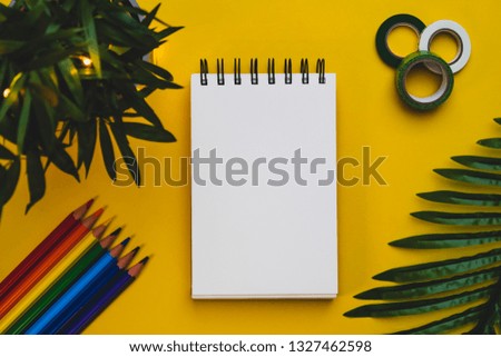 Yellow background with plants and planner supplies and blank space