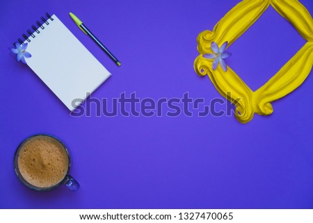 Purple background with yellow frame and flowers and plants and note pad with blank space and coffee mug