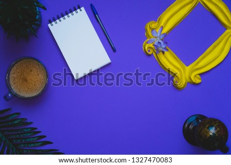 Purple background with yellow frame and flowers and plants and note pad with blank space with coffee mug and globe