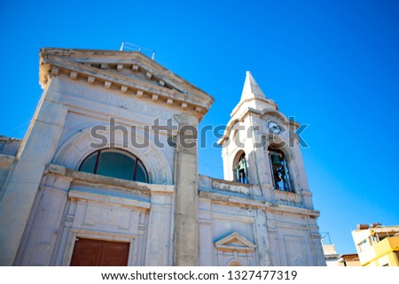 Marble exterior of the Catholic Cathedral (church) with small statues, tower and the note "MARIAE B. VIRGINI DICATUM" (translation - Dedicated to Maiden Marie), Torre Faro, Messina, Sicily. Italy