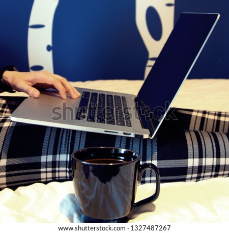 Laptop and coffee cup sitting on bed