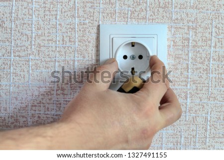 white outlet. the wizard with a screwdriver sets it in place.