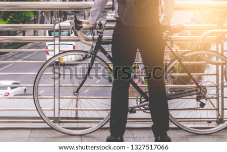 Business man stading with bike on a city traffic