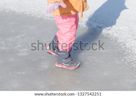 Small child. ride on the ice. he has no skates. close-up.