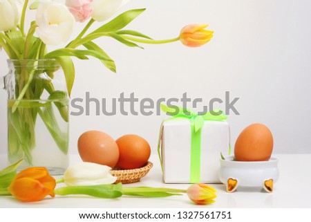 bouquet tulips and eggs on white table with light