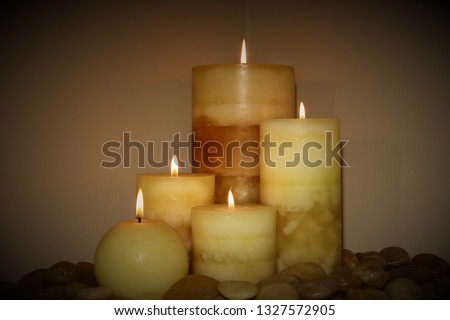 5 lit wax candles, with stones