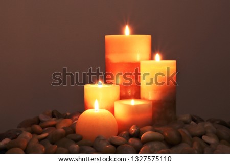 5 lit wax candles with stones