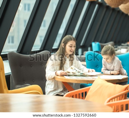 Happy young women mother with children sitting at dinner table and talking in restaurant or cafe. In Leisure and communication with children restaurant
