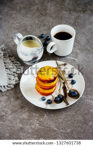 Homemade blueberry muffins with fresh blueberry. Breakfast with cup of coffee, jug of milk over grey concrete table background. Close up, space - Image