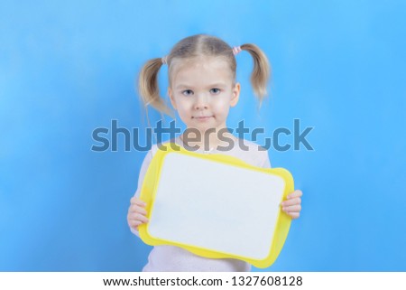 A copy of the space on the plate that is held in the hands of a little girl. A cute child with blond hair. Bright photo with space for text and advertising, mock up.