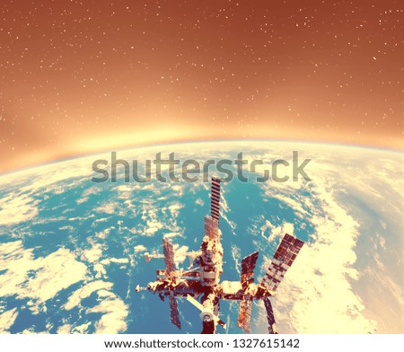 Earth in space and sun rays. International space station on the above. Elements of this image furnished by NASA. 