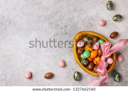 Sweet Sugary Easter Candy eggs in a wooden bowl on light gray backround. Top view