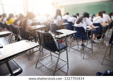 blur focus.abstract background of examination room with undergraduate students inside. university student in uniform sitting on lecture chair taking final exam or study in classroom