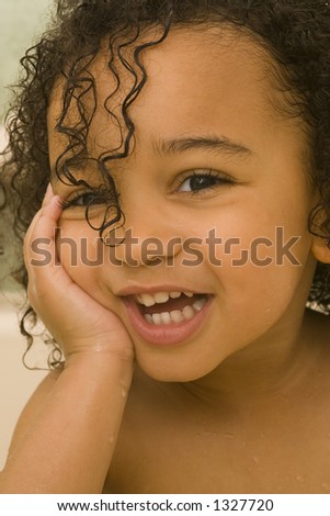 A beautiful mixed race girl with wet hair laughing at the camera