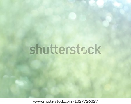 Light green color of blurred background with flare and bokeh,  underexposed or overexposed 