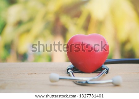 close up red heart and stethoscope on old wood table, nature copy space background for text, world health day, medical and healthcare business technology con ept