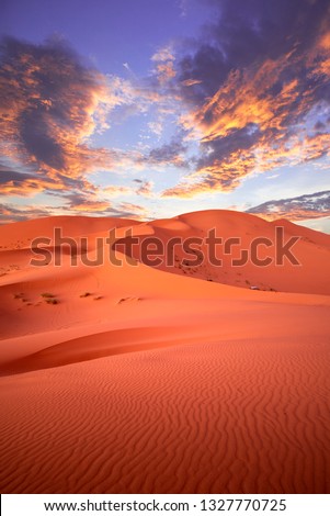 Sunset in the desert. Dunes Erg Chebbi in the Sahara desert near Merzouga, Morocco , Africa. Beautiful sand landscape with stunning sky Royalty-Free Stock Photo #1327770725