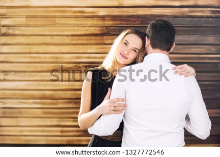 Young adult beautiful couple man and woman happy together on wooden wall background