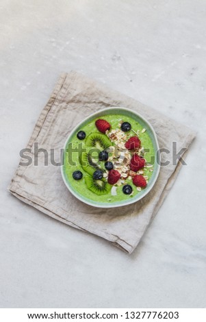 Smoothie breakfast bowls with berries, seeds, oats and nuts on white background with copy space