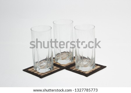 Composition of glasses for juice with stands on a white background.