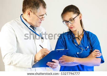 Senior physician tests the knowledge of the young doctor. Close up