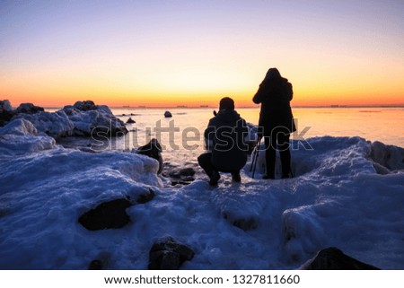 Sunrise by the sea in winter.The rocks were covered with snow and ice