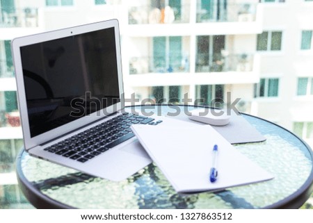 Work office desk with a computer laptop, notebook, pen on the glass table