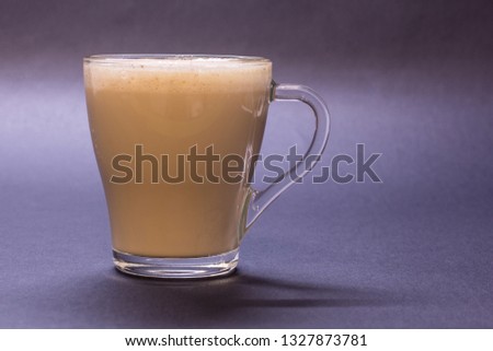 Transparent glass cup with coffee on violet background. Bright tone, soft focus Royalty-Free Stock Photo #1327873781