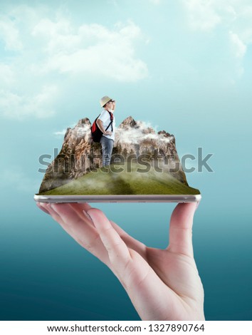 Hand holding a smartphone with a mountain enviroment and a traveller. The concept of booking online for travel.