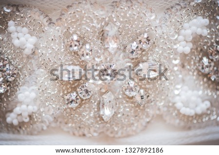 Details of fabric, precious stones and rhinestones in wedding dress
