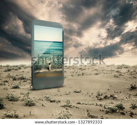 Smartphone on a dry land with a seascape picture on the screen.