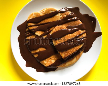 Valentine’s day chocolate pancakes on a yellow surface