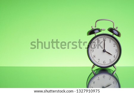 Alarm Clock on green background with selective focus. Copy space  and business concept