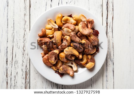 top view cashew nuts on a dish on white wood background