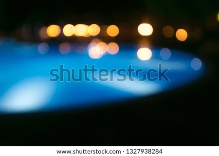 Unfocused background of illuminated swimming pool at night.