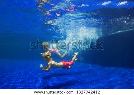 Happy family - funny kids learn to swim, dive underwater with fun. Jump with water splashes in pool. Healthy lifestyle, active people, sports activities, swimming classes on summer holidays with child Royalty-Free Stock Photo #1327942412