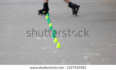 Boy riding on on roller skates. Kid learning to roller skate with cones. Active outdoor sport for kids.