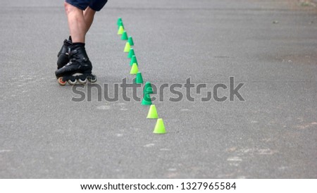 Boy rollerblading on asphalt road. Teenage roller practicing tricks skatepark. Boy learning to roller skate on road with cones. People and active lifestyle concept.