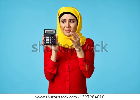  arab woman with calculator on blue background                              