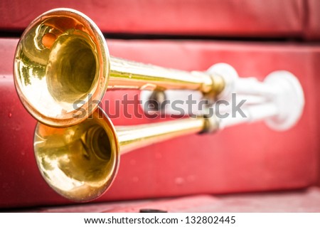 Close up view of two shiny metal horns on red firefighter car. Sound signal used to avoid traffic accidents. Way of warning or informing people about danger. Royalty-Free Stock Photo #132802445