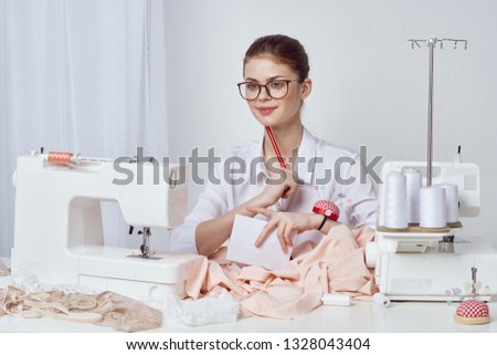   A woman sews clothes on a sewing machine.                            