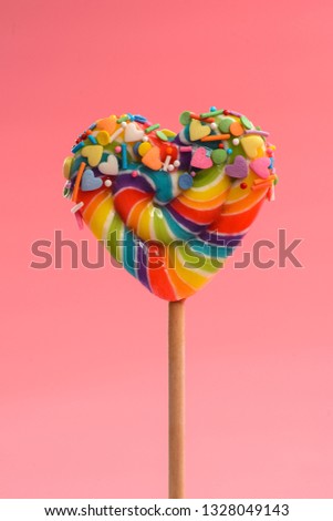 heart shaped lollipop decorated with small sweets and candies
