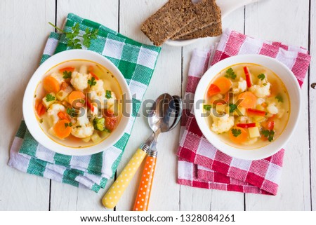 Cauliflower soup with potatoes, carrots and other vegetables on white background