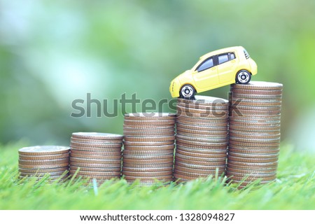 Miniature yellow car model on growing stack of coins money on nature green background, Saving money for car, Finance and car loan, Investment and business concept  Royalty-Free Stock Photo #1328094827