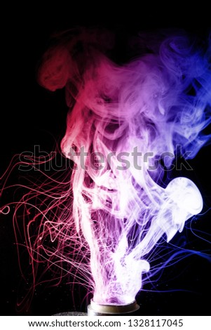Colorful cloud splash with spray boiling liquid. Two colours fog is hue blue and hue red. Stock photo isolated on black background.